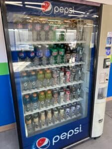 A Pepsi-branded vending machine used by a large vendor, stocked with a wide selection of bottled beverages, including Pepsi, Mountain Dew, Gatorade, and Starbucks drinks